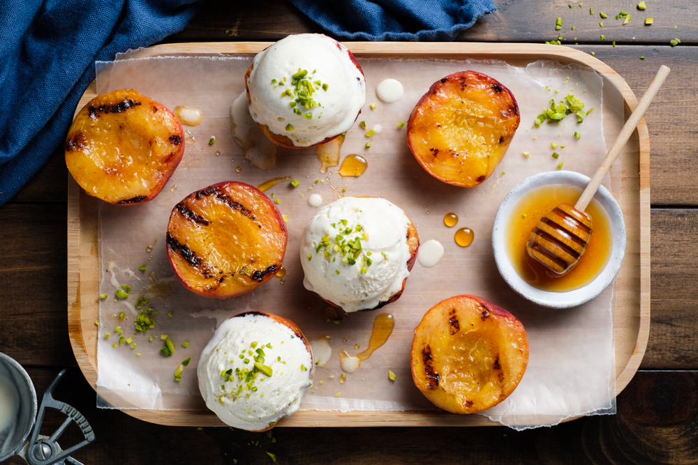 Grilled peach halves with vanilla ice cream and pistachios