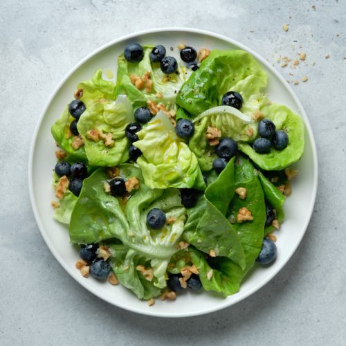 Butter lettuce, blueberry and walnut salad on a platter