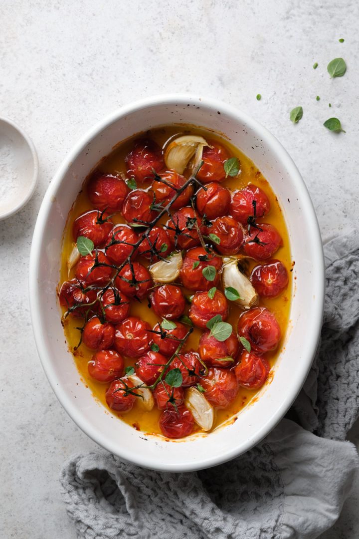 Roasted cherry tomatoes with garlic and herb garnish